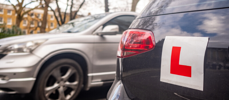 Car parked in a bay with an L-plate displayed