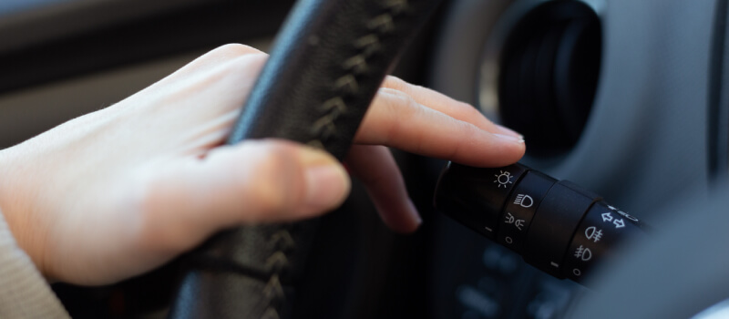 Hand pressing the indicator downwards in the car