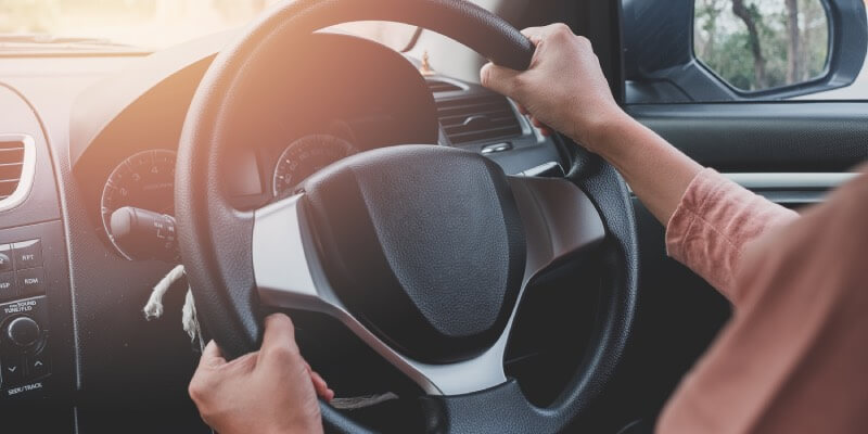Two hands on a steering wheel