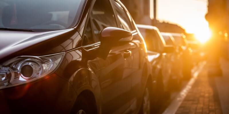 Blurred row of parked cars with sunset behind