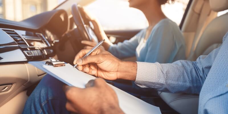 Examiners hand marking the driving test sheet