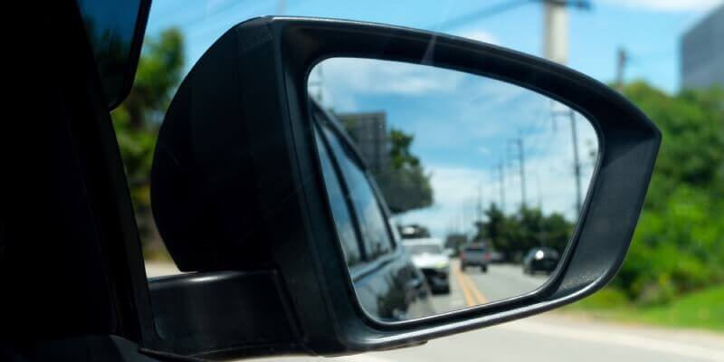 Drivers side wing mirror showing blurred cars behind