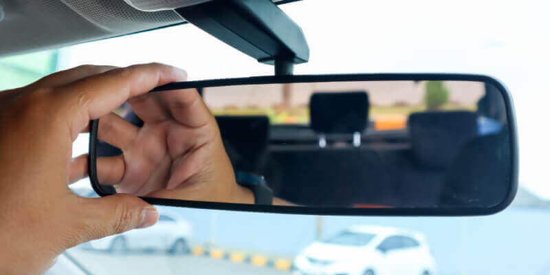 Hand adjusting the rearview mirror