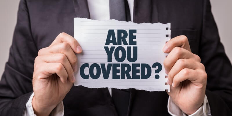 Man in suit holding a sign that reads: are you covered?
