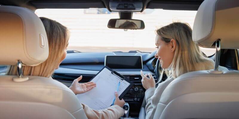 Instructor and girl discussing whilst looking at clipboard